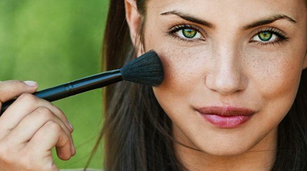 Beautiful Woman applying makeup to her face.