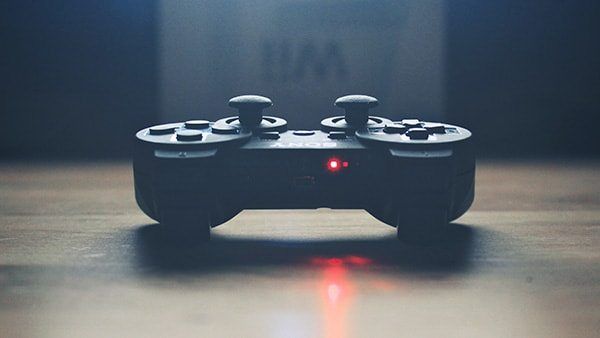 Playstation 3 controller on a table in front of a wii box