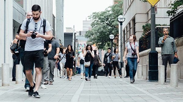 Pedestrians walking on the street shooting video