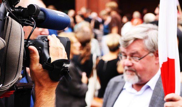 Videographer on the Field. News videographer filming George Lucas